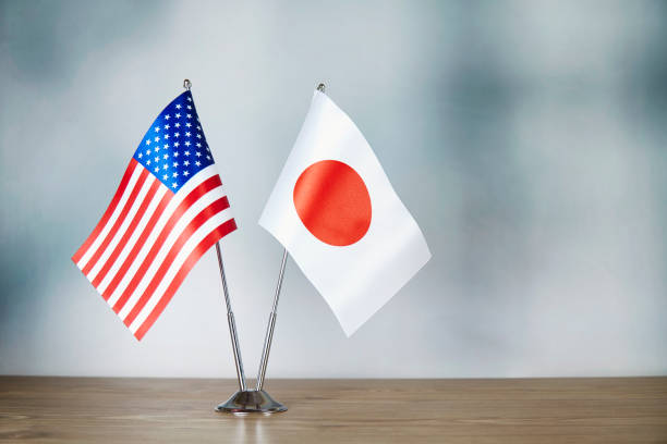 American and Japanese flag standing on the table with defocused background